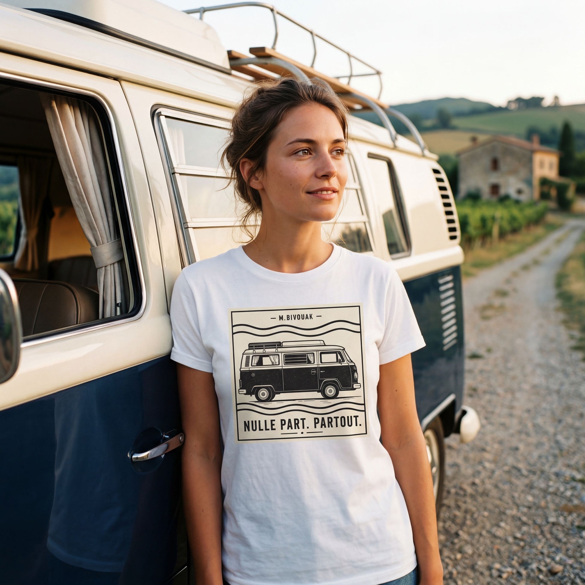 Femme portant le t-shirt Nulle part. Partout. blanc en coton en conversion biologique devant un combi VW. M.Bivouak, vanlife.