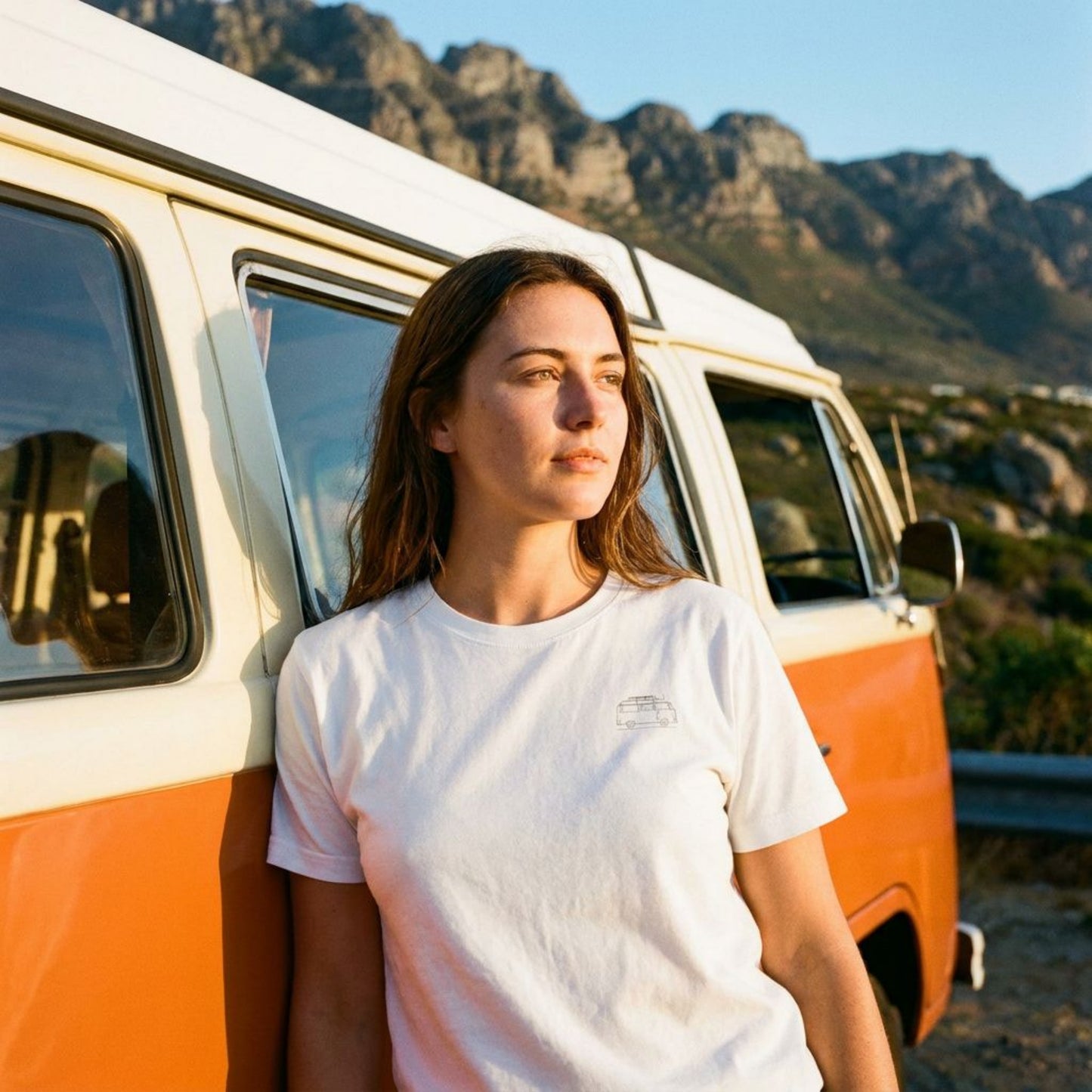 Femme portant le t-shirt Van Signature blanc devant un combi VW en montagne. M.Bivouak, vanlife.